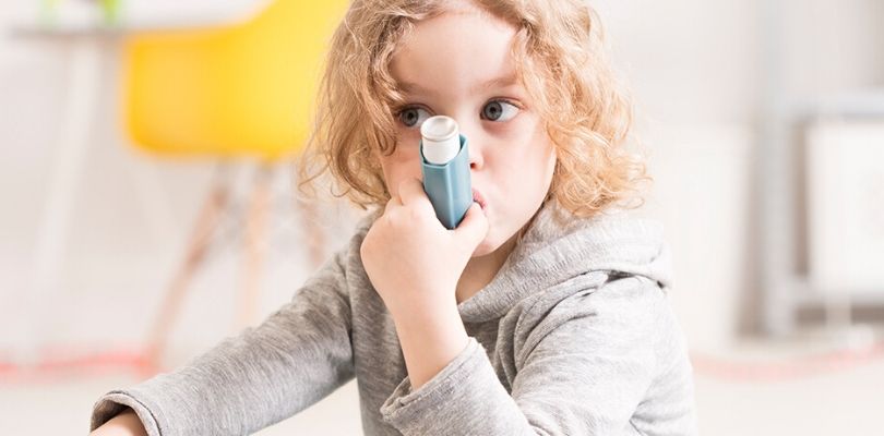 A toddler using an inhaler.